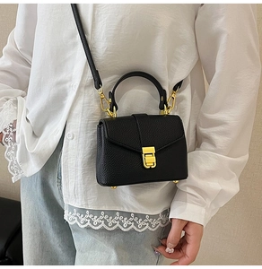 Classic black lychee pattern handbag with gold hardware shown as a crossbody bag on model