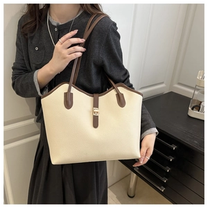Detail of lychee textured tote bag with contrast brown straps and gold metal lock buckle
