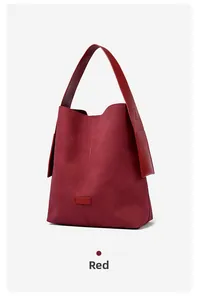 Detail view of large red hobo bag showing matte suede texture and leather accents