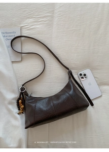 Détail du sac vintage marron foncé avec perles en bois et texture de cuir mat élégante