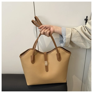 Detail of lychee pattern leather tote bag with contrast stitching and metal buckle lock