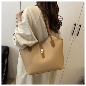 Detail view of high-quality lychee texture leather tote with metallic buckle and slim straps