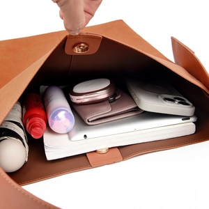 Spacious interior of orange-brown tote bag showing storage for tablet and daily items
