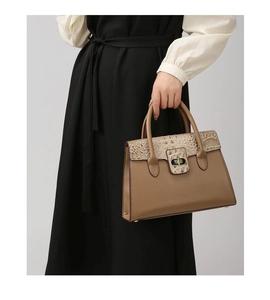 Detail of vintage leopard handbag with golden twist lock and brown crocodile texture