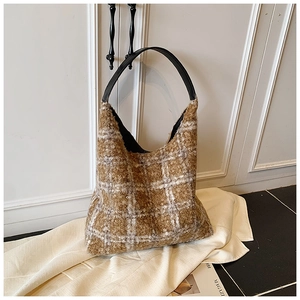 Chic checkered lamb wool hobo bag with black leather handle in warm home setting