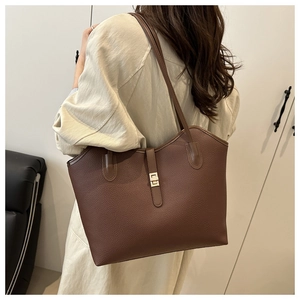 Brown lychee leather tote bag with gold lock shown on model for size perspective