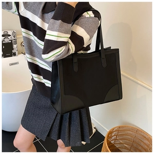 Minimalist black faux leather tote bag with long shoulder straps for daily commute