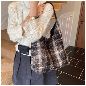 Detail of black and white checkered faux fur tote bag with a premium leather shoulder strap
