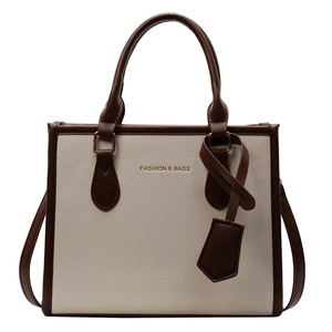 Fashionable bicolor tote bag in cream white leather with dark brown handles and text