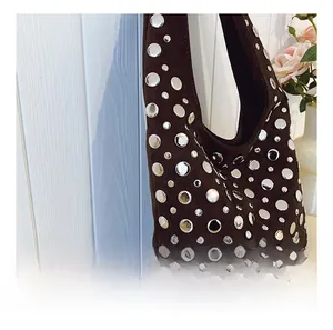Dettaglio della borsa hobo in pelle scamosciata marrone scuro con borchie in metallo