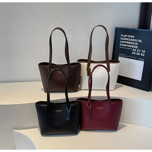Detailed close-up of tote bags in four colors on a modern display with pebbled leather texture