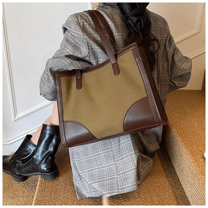 Detail of minimalist tote bag with olive green canvas and dark brown leather contrast