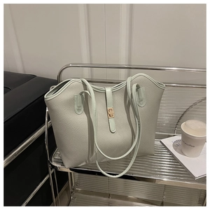 Close-up of mint green lychee pattern tote bag featuring a gold metal twist lock