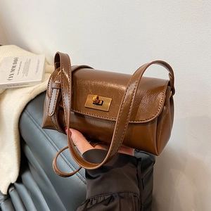 Brown glossy pillow bag with vintage gold swivel lock and slender shoulder strap