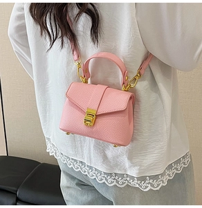 Detailed side view of pink litchi grain crossbody bag with gold clasp and shoulder strap