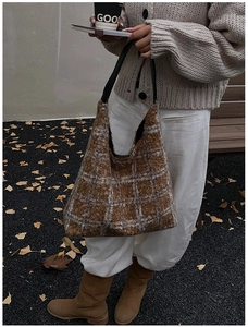 Detailed close-up of brown checkered faux shearling tote bag with leather strap