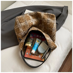 Close-up of spacious interior in brown and white plaid fleece bucket bag with daily items