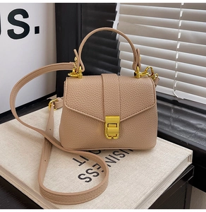 Detailed view of light brown litchi grain leather texture and gold metal buckle
