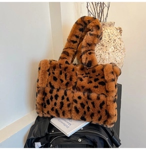 Detail of plush leopard print tote bag placed on a leather jacket with lifestyle props