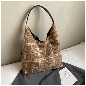Close-up of the thick brown and white checkered fuzzy fabric and black leather handle