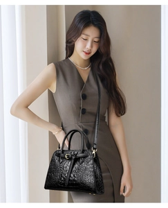 Chic black crocodile embossed tote bag styled with a brown dress on a model