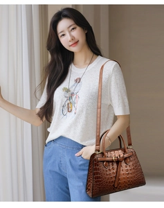 Brown crocodile pattern handbag featuring a gold turn-lock and adjustable shoulder strap