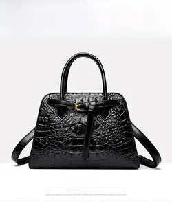 Front view of black crocodile pattern handbag with glossy finish and gold buckle detail