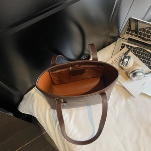 Top view of spacious brown leather tote bag showing orange lining and magnetic closure
