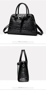 Detail view showing black crocodile pattern leather texture and side profile of handbag