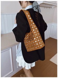 Borsa a spalla in pelle scamosciata marrone con borchie metalliche indossata da modella