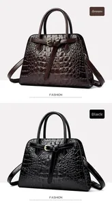 Detail view of crocodile pattern leather handbags in brown and black with gold buckles