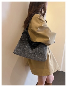 Detail of a black shoulder bag with gradient silver rhinestones on a khaki coat