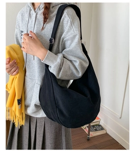 Detailed view of the black canvas hobo bag showing adjustable silver buckle on a model