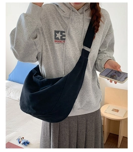 Detail of black crescent hobo bag with wide adjustable shoulder strap on model