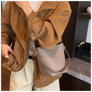 Detail of high-quality pebbled leather bucket bag in taupe with fine stitching