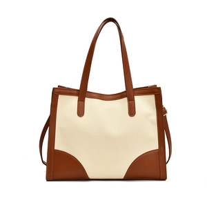 Minimalist canvas tote bag with brown leather trim and color-block stitching design
