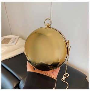 Détail de la pochette de soirée sphérique dorée avec finition en métal poli miroir