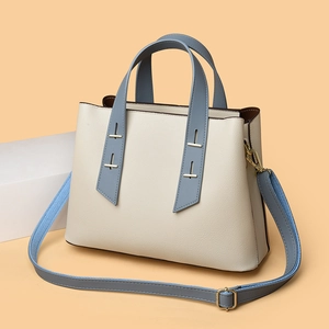 Close-up of contrast color tote bag with pebble leather texture and gold hardware