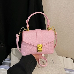 Pink lychee texture crossbody bag with gold buckle on a stylish lifestyle background