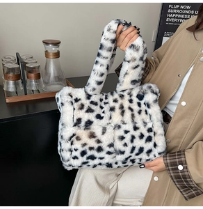 Detail shot of a large leopard print faux fur tote bag styled with a trench coat