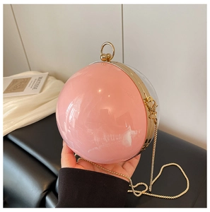 Détail du sac de soirée boule en acrylique rose avec chaîne dorée et fermoir anneau