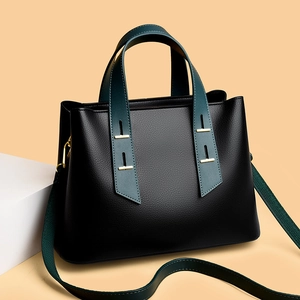 Detail of lychee pattern leather tote with gold hardware and contrast handles