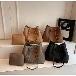 Chic bucket tote bags set in khaki and grey colors displayed on a marble background