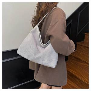 Silver rhinestone shoulder bag with half-moon shape worn by model on shoulder