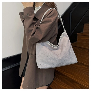 Silver rhinestone hobo bag on shoulder, sparkling detail for winter party fashion