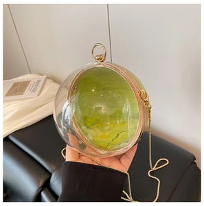Détail d'un sac de soirée sphérique en acrylique avec pochette citron et chaîne dorée