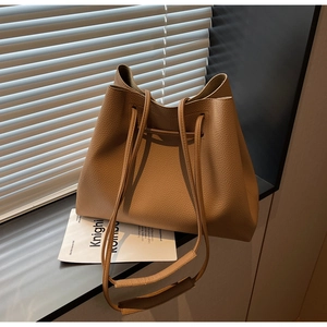 Detail of caramel lychee grain bucket bag with drawstring closure and soft texture