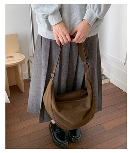Detail of dark brown large capacity crossbody dumpling bag with wide shoulder strap