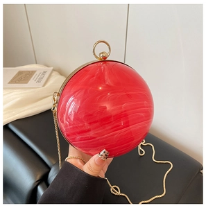 Détail du sac de soirée sphérique en acrylique marbré rouge avec poignée dorée