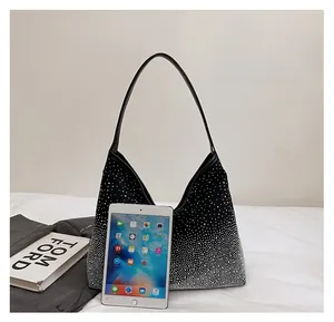 Detailed size comparison of a gradient rhinestone hobo bag next to an iPad mini